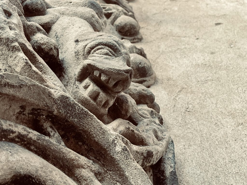 Steinernes Relief mit Gesicht und Dekor