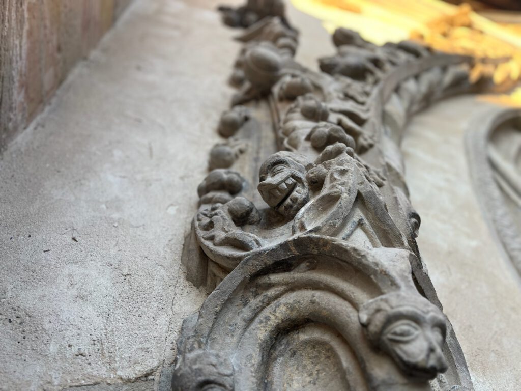 Detailreiche Steinmetzarbeit an historischer Fassade.