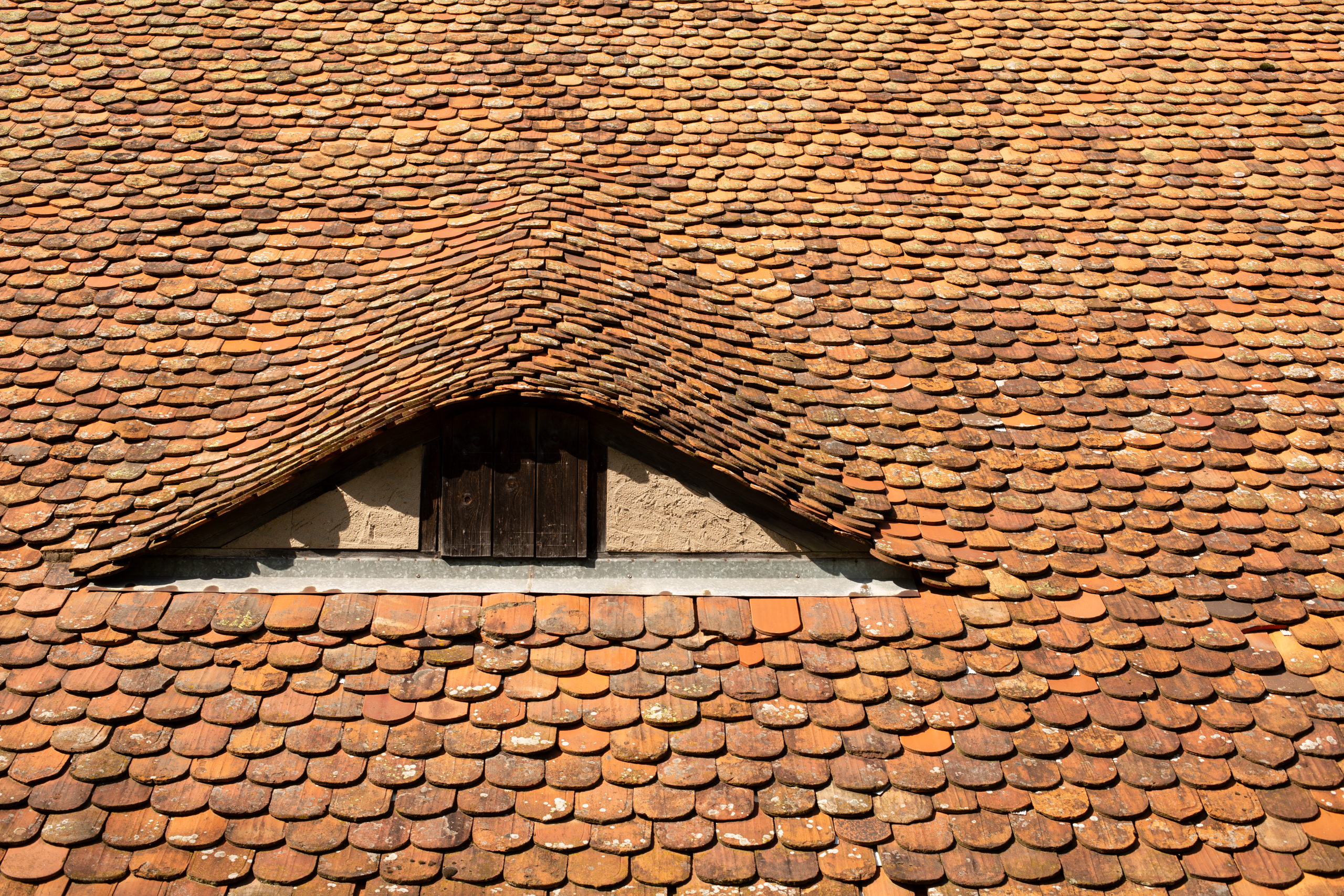 Detail eines Dachs mit Holzschindeln und Gaube